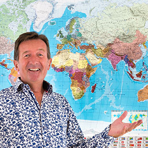 Photo of David, in front of a world map